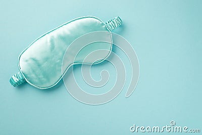 Top view photo of an attractive big blue silk and luxurious mask for sleep situated on pastel light blue isolated background back Stock Photo