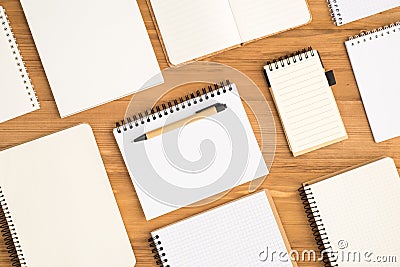 Top view photo of composition of different small and big open planners and pen on isolated wooden desk background with empty space Stock Photo