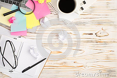 Top view photo of cup of coffee binder clips multicolor sticker note paper magnifier laptop glasses pen notebooks and crumpled Stock Photo