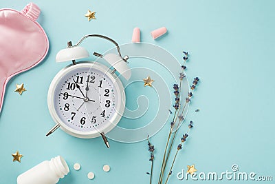 Top view photo of white alarm clock sprig of lavender pink silk sleeping mask pink earplugs open bottle with pills and golden Stock Photo