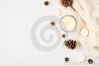 Top view photo of winter composition lighted candles white knitted scarf pine cones and anise on isolated white background with Stock Photo