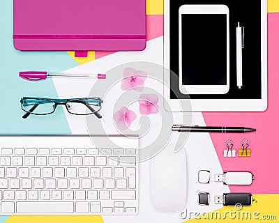 Top view photo of workspace with blank mock up tablet and smartphone, coffee cup, keyboard, and notepad on pastel background. Stock Photo