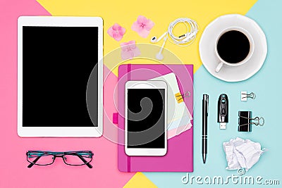 Top view photo of workspace with blank mock up tablet and smartphone, coffee cup, notepad and glasses on pastel background. Stock Photo