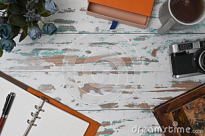 Top view photographer workspace with notebook, camera and coffee cup on wooden background. Stock Photo