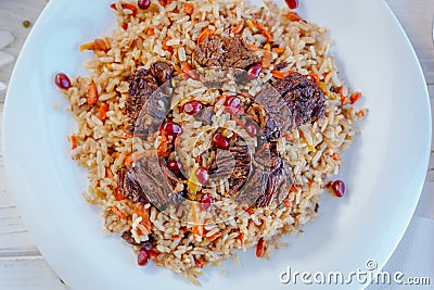 Top view of pilaf or plov with meat on a white plate. Stock Photo