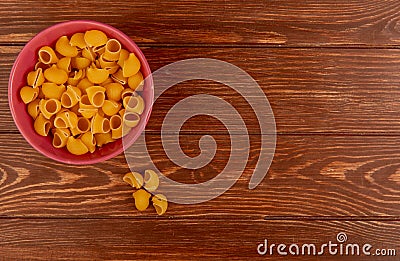 top view of pipe-rigate pasta in bowl on wooden background with copy space Stock Photo