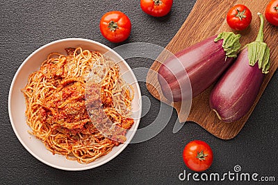 Top view plate EGGPLANT PASTA like a Calabrese and vegetables for cooking on dark background Stock Photo