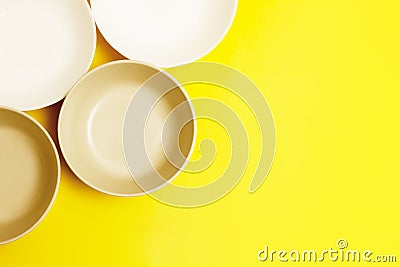 Top view plates on yellow background with copy space. Stock Photo