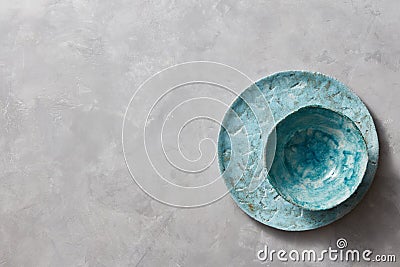 Traditional souvenir clay handmade colorful plate and bowl on a gray concrete background with place under text. Flat lay Stock Photo