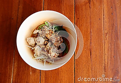 Top view Pork noodles, a popular local Asian food in Thailand, noodles with a wide variety of vegetables on the dining table. Stock Photo