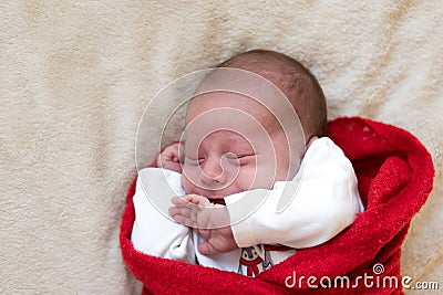 Top View Portrait First Days Of Life Newborn Cute Sleeping Baby In pajamas Wrapped In Red Diaper rug At White soft Stock Photo