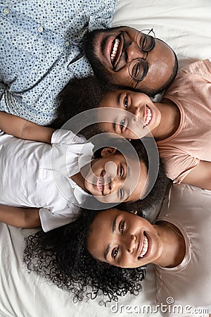 Top view portrait of smiling black family lying on bed Stock Photo