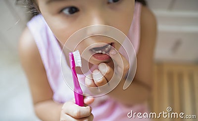 Top view portrait of worried small girl indoors, loosing baby tooth. Stock Photo