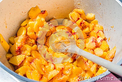 Top view of a pot full with cut peaches. Homemade peach jam cooking. Stock Photo