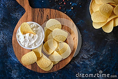 Top view potato chips, sauce in a white bowl on a wooden cutting board Stock Photo