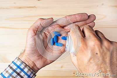 Top view pov of adult man taking blue pills Stock Photo