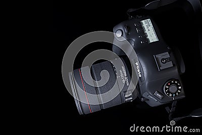 Top view professional digital camera with a zoom lens and a leather strap on a black background with copy space. View Stock Photo