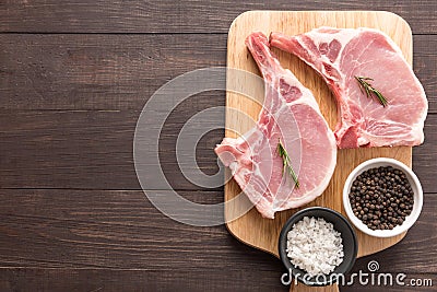 Top view raw pork chop steak and garlic, pepper on wooden backgr Stock Photo