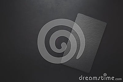 Top view on rectangle black slate plate on rustic dark background. Copy space. Toned Stock Photo