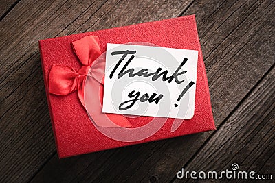 Top view red gift box and label with the words thank you on wooden background: concept of expressing gratitude and thanks Stock Photo