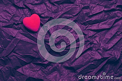 Top View Red Heart On Wrinkled Dark Purple Texture Background. Happy Valentine`s Day And Love Concept. Romantic Card, Banner Stock Photo