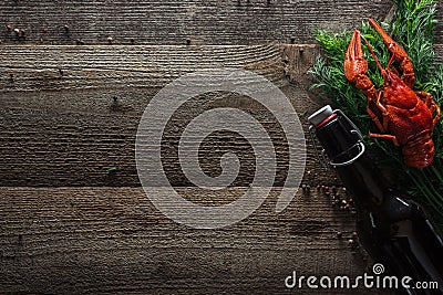 Top view of red lobster, dill and bottle with beer on wooden surface. Stock Photo
