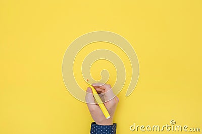 Top view right hand holding a pen yellow background Stock Photo