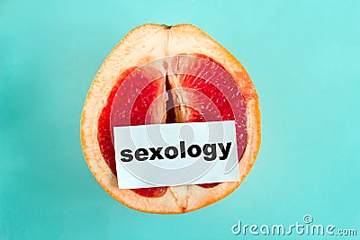 ripe juicy grapefruit with note sexology isolated on a blue background Stock Photo