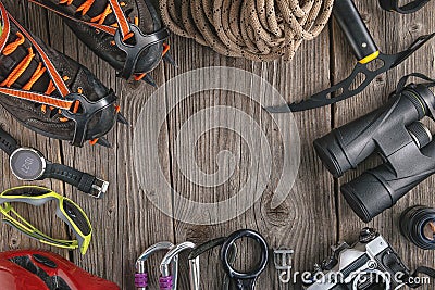 Top view of rock climbing equipment on wooden background. Chalk bag, rope, climbing shoes, belay/rappel device, carabiner and asce Stock Photo