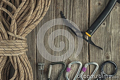 Top view of rock climbing equipment on wooden background. Chalk bag, rope, climbing shoes, belay/rappel device, carabiner and asce Stock Photo