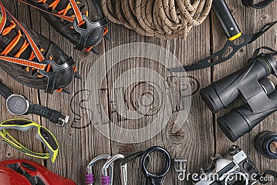 Top view of rock climbing equipment on wooden background. Chalk bag, rope, climbing shoes, belay/rappel device, carabiner and asce Stock Photo