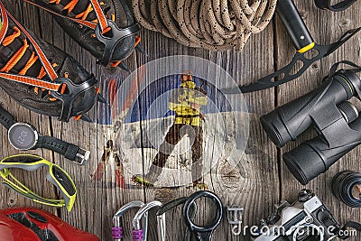 Top view of rock climbing equipment on wooden background. Chalk bag, rope, climbing shoes, belay/rappel device, carabiner and asce Stock Photo