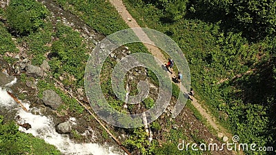 Top view rocky hiking trail and rapid mountain stream three tourists. Top view rocky hiking trail and rapid mountain stream. Three tourists with backpack and stock footage Top view rocky hiking trail and rapid mountain stream three tourists. Top view rocky hiking trail and rapid mountain stream. Three tourists with backpack and stock footage