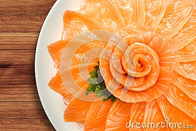 Top view of salmon sashimi serve on flower shape in white ice bowl boat on wood table background, Japanese style Stock Photo