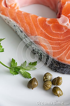 Top view of salmon slice with parsley and capers on white plate Stock Photo