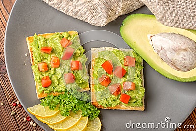 top view of sandwiches with latin american mexican sauce guacamole with avocado and white bread toast decorated diced tomatoes, s Stock Photo