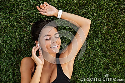 Top view of a satisfied fitness girl in earphones laying Stock Photo