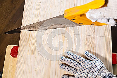 Top view of sawing solid wood board with hand saw Stock Photo