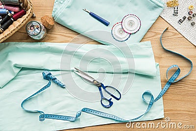 top view of seamstress workplace on table with fabric, scissors, needles, measuring tape Stock Photo