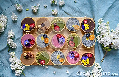 Top view of selection of colorful and delicious cake desserts in box on table. Stock Photo