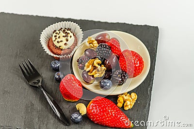 Top view on set of various nuts and fruit with chocolate muffin Stock Photo