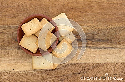 Hard bread crackers in a bowl atop a wood board Stock Photo