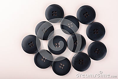 Top view of several sewing buttons on a light beige background. Stock Photo