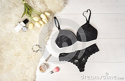 Flat lay stylish black lingerie accessories and white tulips on a white background. Valentine`s Day 8 March party outfit Stock Photo