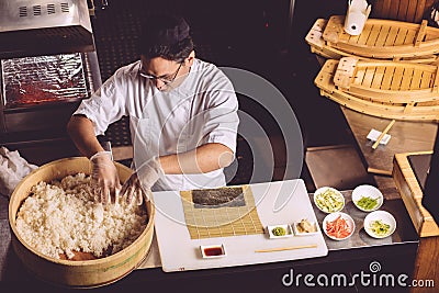 Top view shot. hardworking chef taking rice to prepare roll Stock Photo