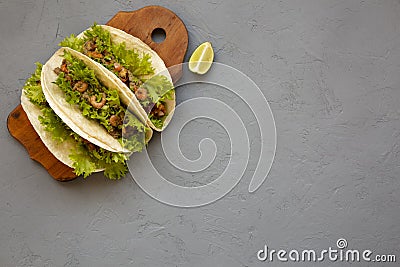 Top view, shrimp tacos on a rustic wooden board on a gray background. Flat lay, from above, overhead. Mexican cuisine. Copy space Stock Photo