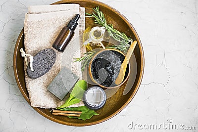 Top view of skincare ingredients with charcoal mask, olive oil, herbal botanical essential oil bottle, natural soap, rosemary herb Stock Photo