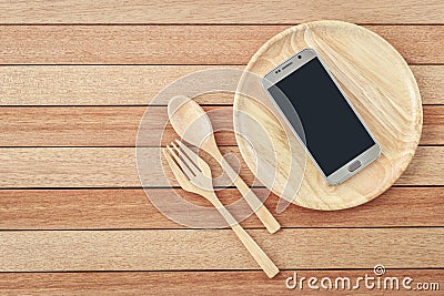 Top view smartphone on wooden dish on wooden plank background Stock Photo