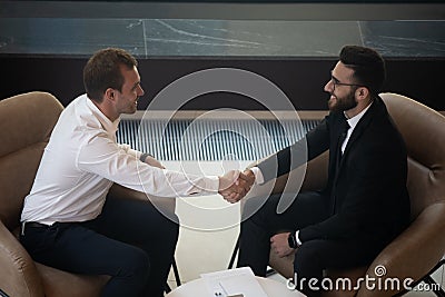 Top view of smiling multiethnic businessmen handshake greeting at meeting Stock Photo