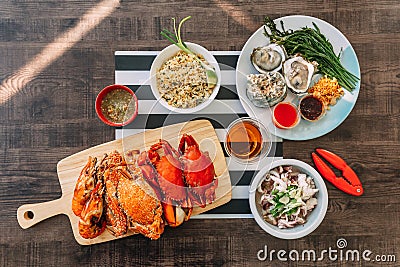Top view of Steamed Giant Mud Crabs, Steamed Flower Crabs and Grilled Shrimps Prawns in wooden chopping board, Crab Fried Rice. Stock Photo